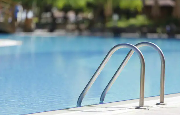 Handles of a ladder leading into a pool